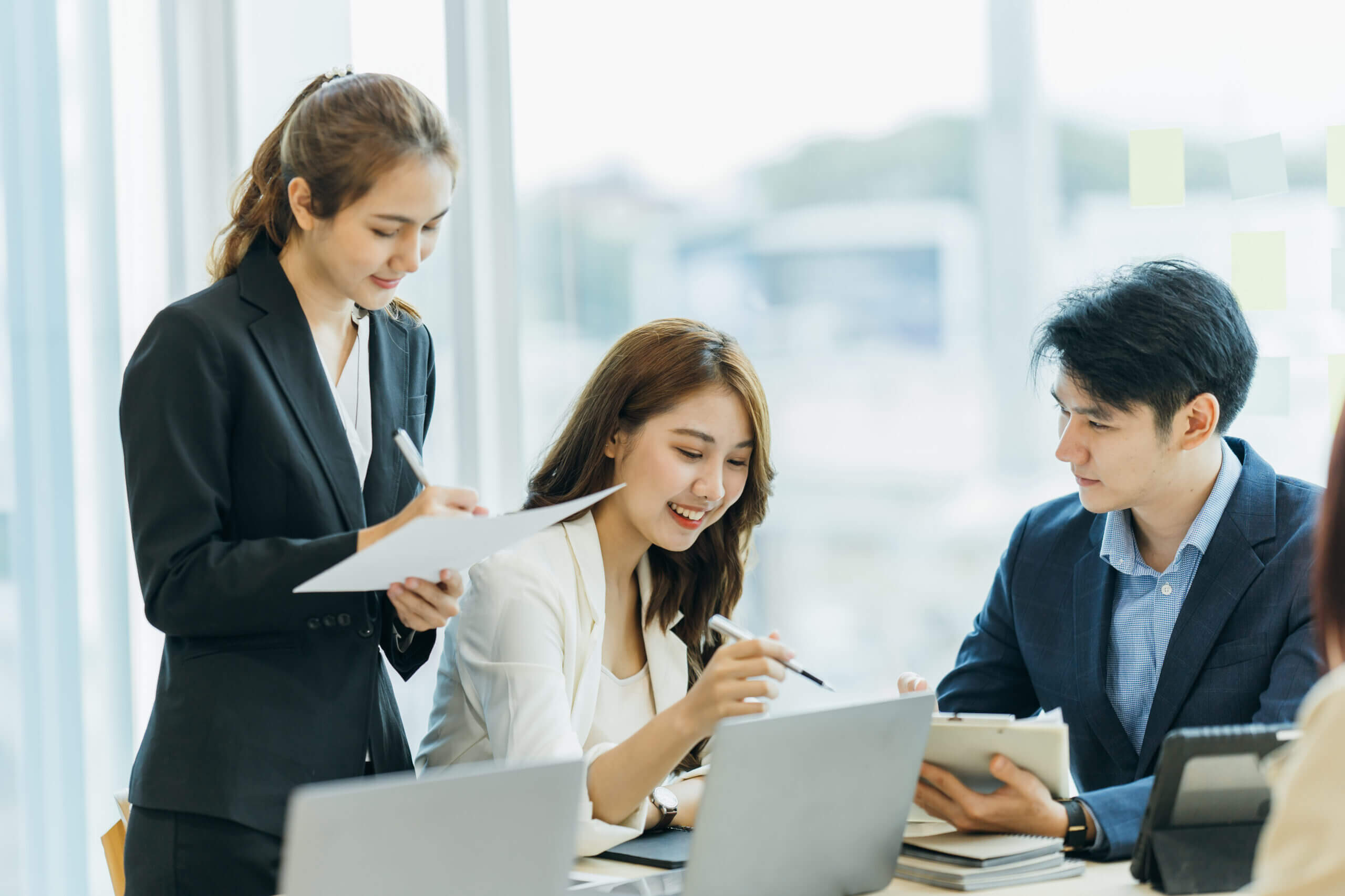 オフィスでスーツの3人が話し合っている画像